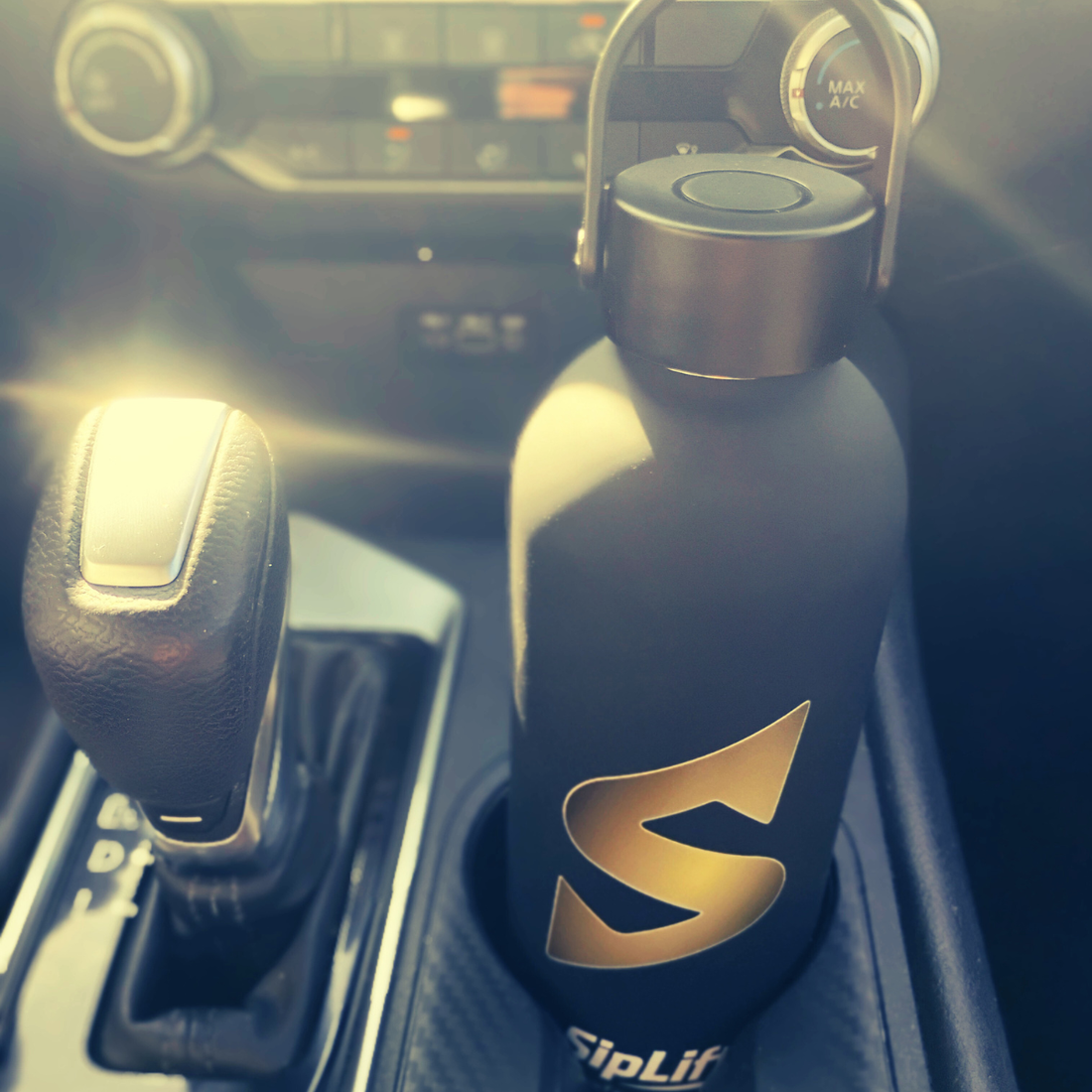 SipLift Signature Hydration Flask sitting in car cupholder